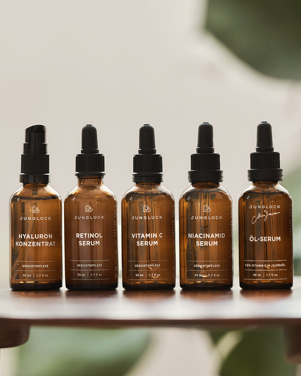 Fünf Braunglasflaschen mit verschiedenen Seren für die Gesichtspflege: Hyaluron Konzentrat, Retinol Serum, Vitamin C Serum,