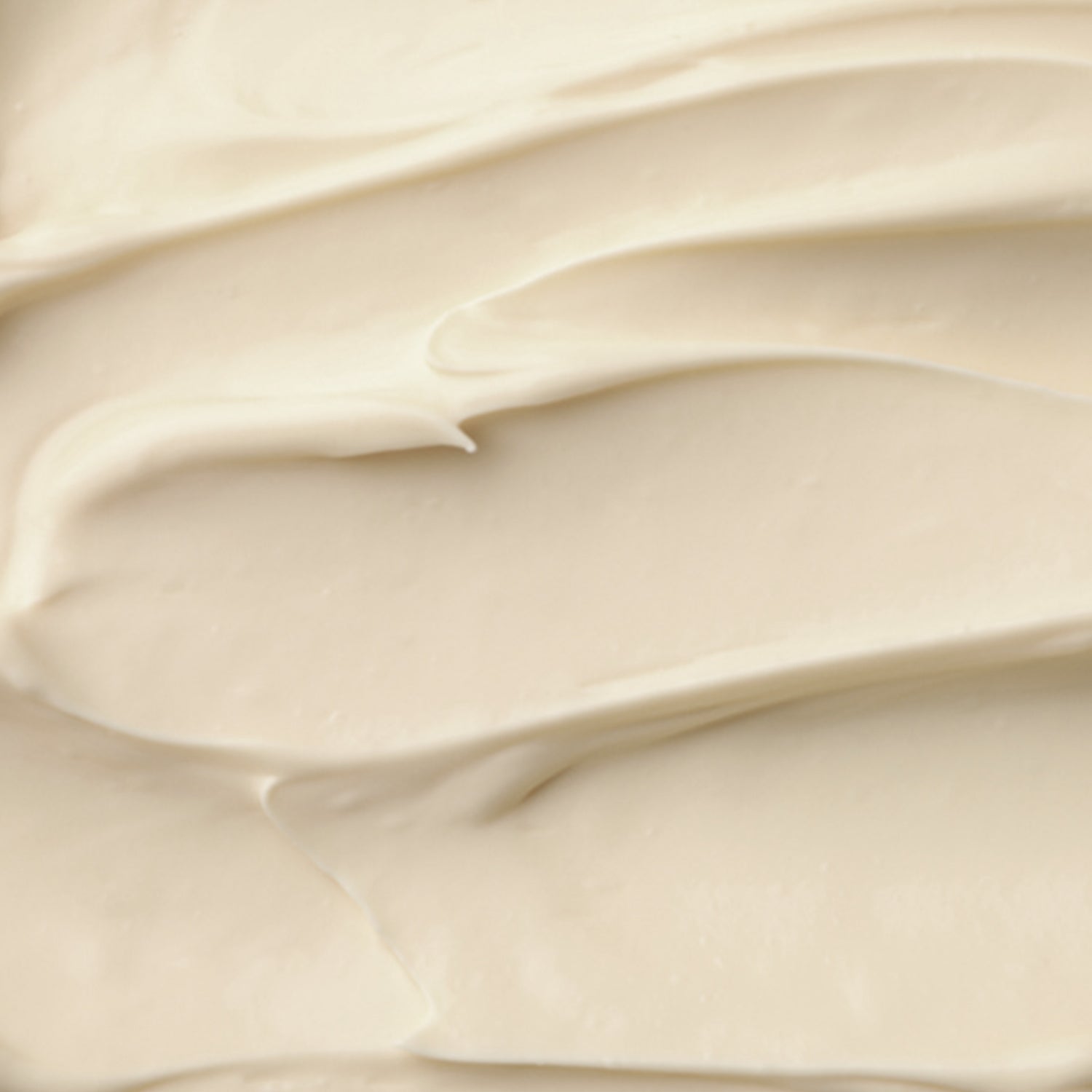 Sahnige, cremige Textur von Mangobutter in hellbeiger Farbe, glatt und gleichmäßig verteilt.