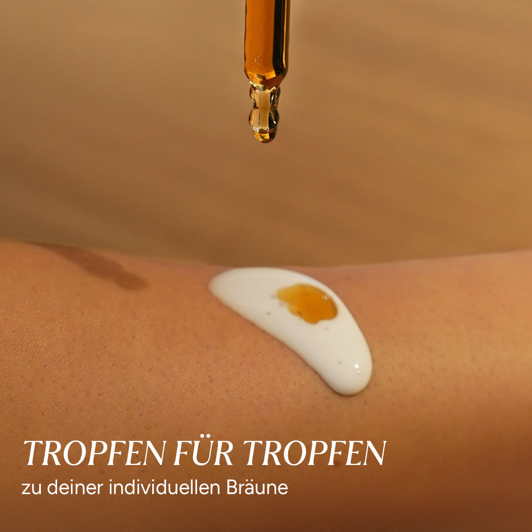 Braunglasflasche mit einem Tropfen Sonnentropfen auf skinnaher Oberfläche. Creme in hellem Ton auf der Haut.