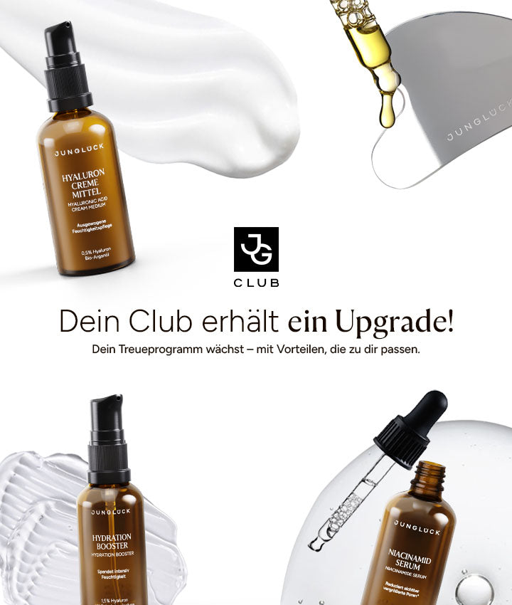 Verschiedene JUNGLÜCK Produkte in Braunglasflaschen: Hyaluron Creme, Hydration Booster, Niacinamid Serum. Hintergrund mit