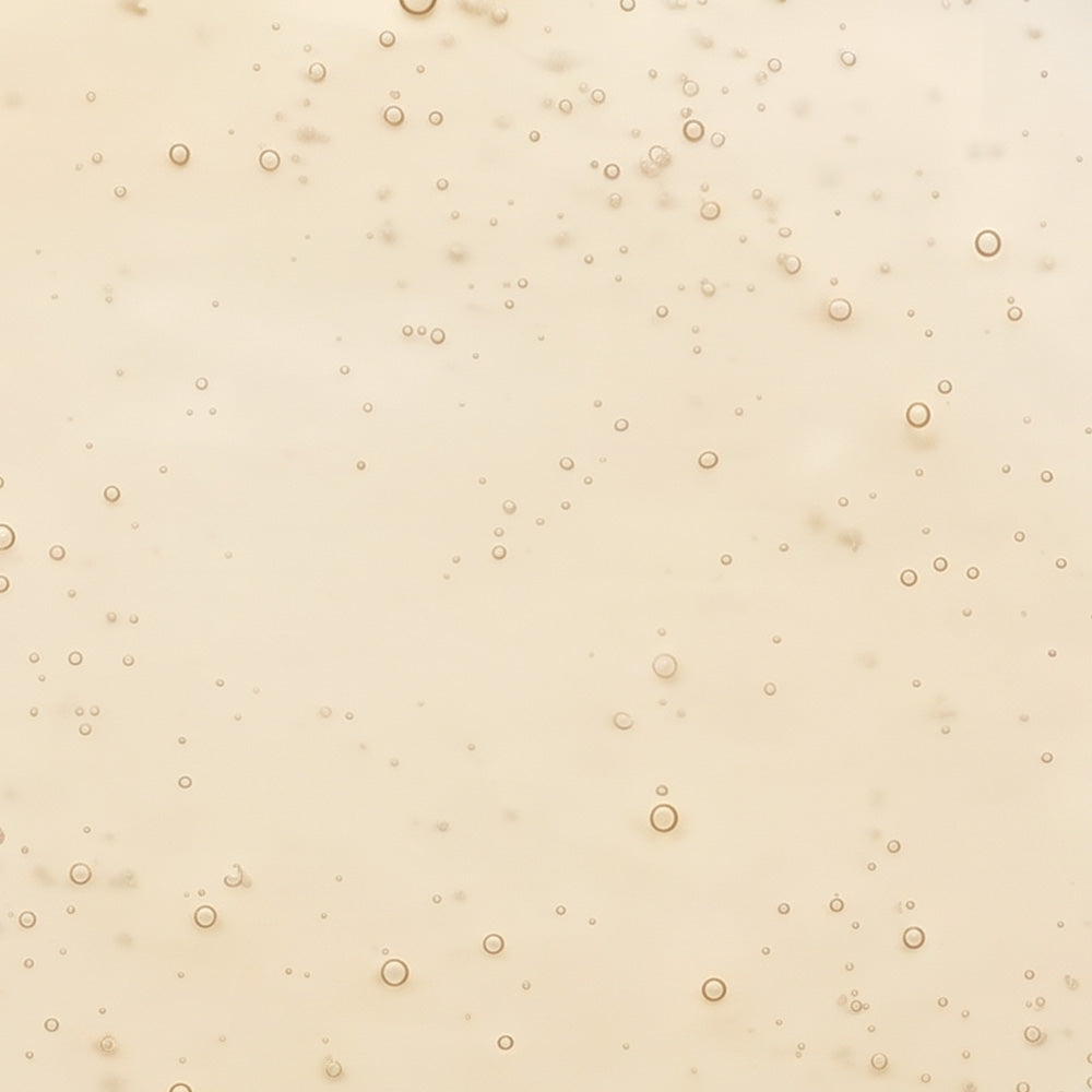 Helle, cremige Textur mit zahlreichen kleinen Bläschen, die einen zarten Schimmer erzeugen.