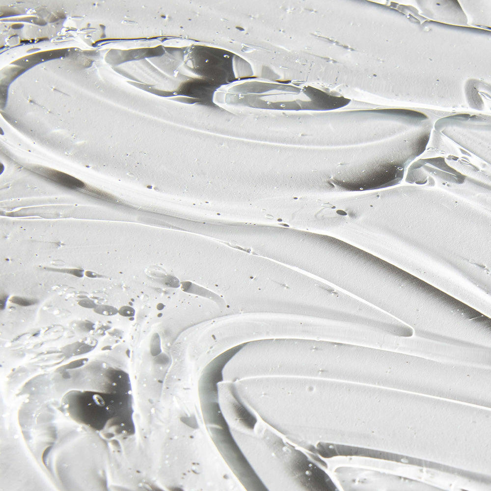 Transparente, gelartige Textur mit sanften Wellen und kleinen Bläschen auf einer glatten Oberfläche.