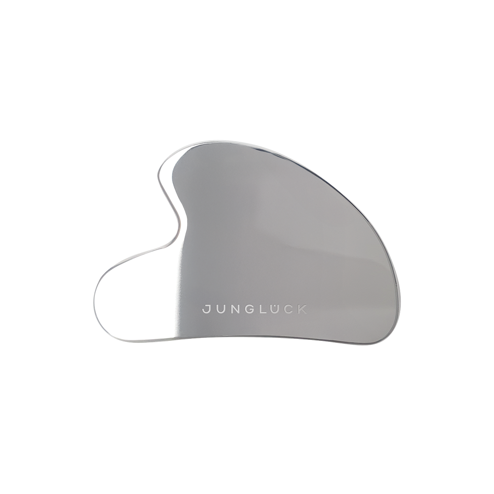 Gua Sha Flach in silberner Farbe mit geschwungener Form, trägt das Logo JUNGLÜCK. Ideal für die Gesichts- und Körpermassage.