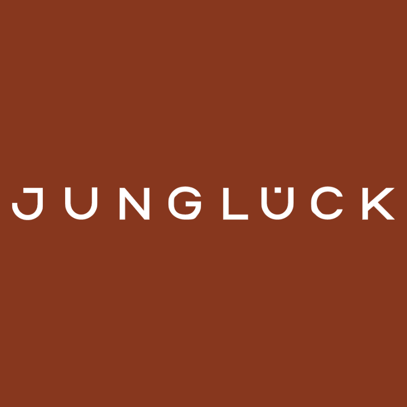 Logo von JUNGLÜCK auf einem rostbraunen Hintergrund.