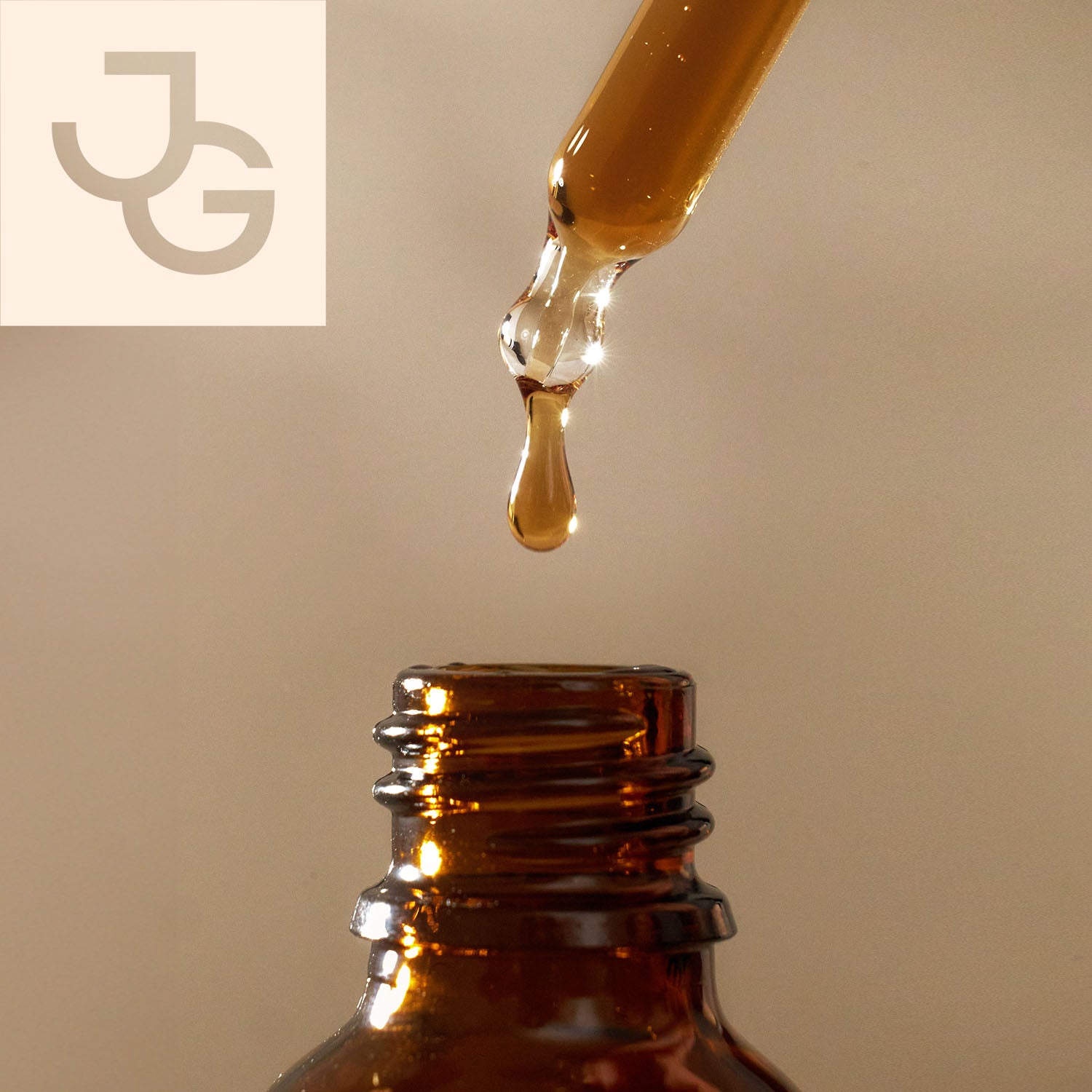 Ein Braunglasflasche mit Pipette, aus der ein Tropfen einer goldenen Flüssigkeit fällt.