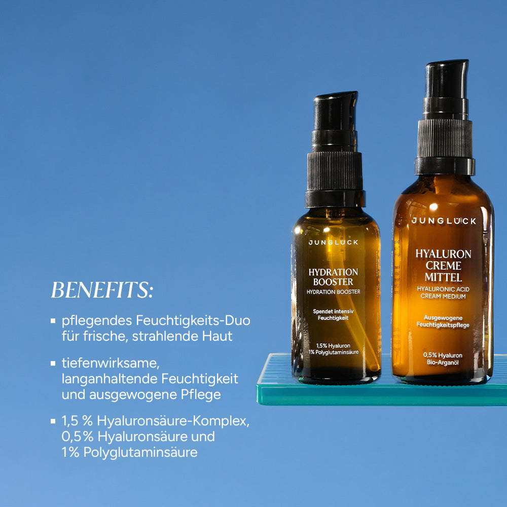 Braunglasflaschen von JUNGLÜCK: Hydration Booster und Hyaluron Creme Mittel, beide mit 0,5% Hyaluronsäure, auf blauem