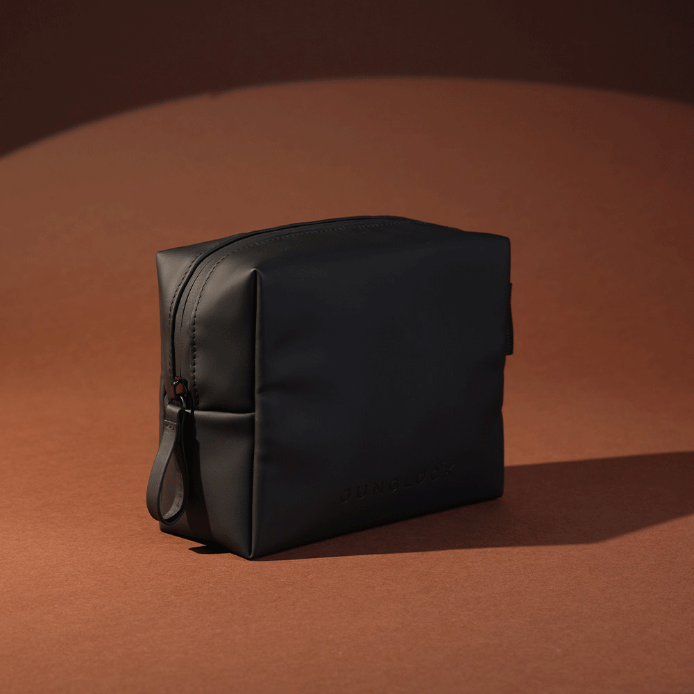 Schlichte, schwarze Kosmetiktasche mit dezenter JUNGLÜCK-Prägung, elegant und funktional.