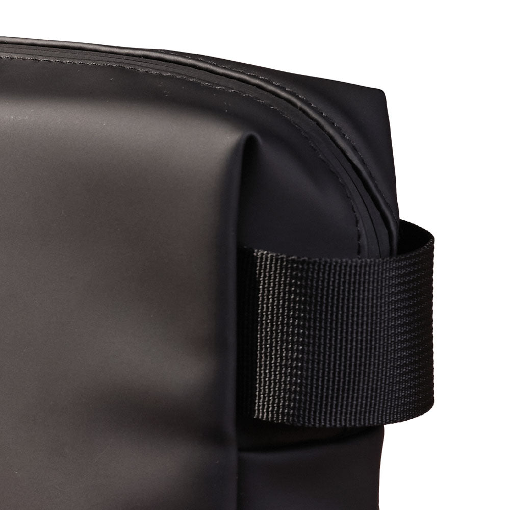 Detailansicht einer schwarzen Kosmetiktasche mit einer Schlaufe für einfachen Transport.