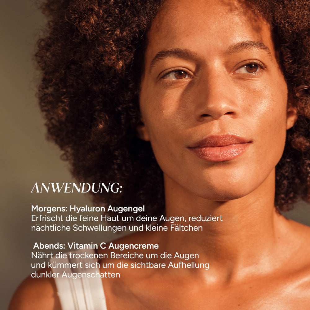 Dunkelhäutige Frau mit natürlichem Teint lächelt sanft. Im Bild sind Texte zur Anwendung von Hyaluron Augengel und Vitamin C